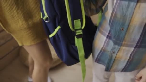 Madre llevando al niño a la escuela y dándole una mochila . — Vídeos de Stock