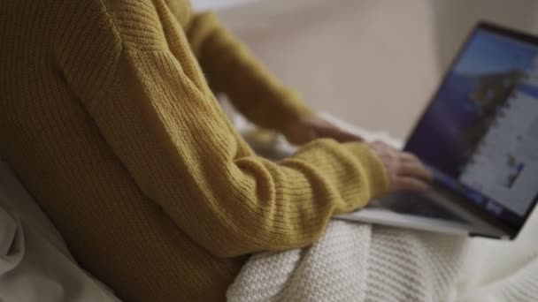 Estudiante usando el ordenador portátil en casa acostado en el sofá debajo de la manta usando serching ordenador para la consulta en línea. Concepto de personas y dispositivos . — Vídeos de Stock