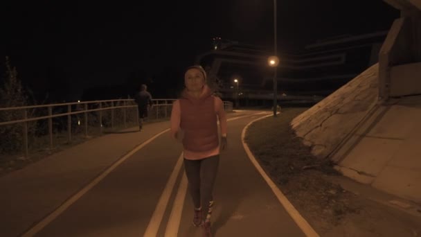 Uma mulher a correr ao ar livre na noite. ISO elevado . — Vídeo de Stock