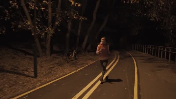 Mujer corriendo al aire libre en la noche. Alta ISO . — Vídeo de stock