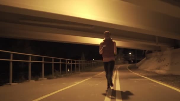 Una donna che corre all'aperto la notte. ISO elevato . — Video Stock