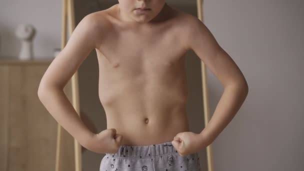 Χαριτωμένο καυκάσιο αγόρι δείχνει μυς στο μπροστινό καθρέφτη, αθλητική δύναμη, υγειονομική περίθαλψη. — Αρχείο Βίντεο