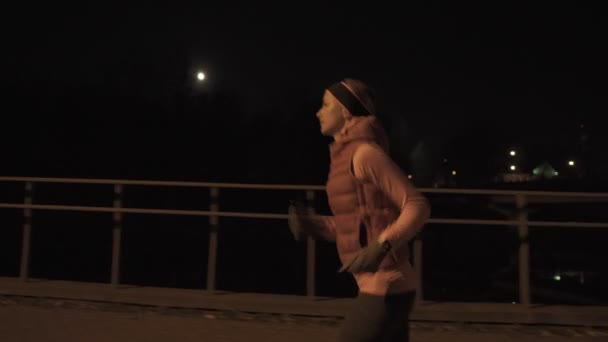 Kvinnan kör utomhus på natten. Höga Iso. — Stockvideo