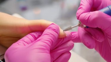 Manikürcü ustası müşterilere oje sürerken tırnak cilası, ellere yakın çekim yapıyor. Güzellik salonunda profesyonel manikür. Hijyen ve el bakımı. Güzellik endüstrisi konsepti.