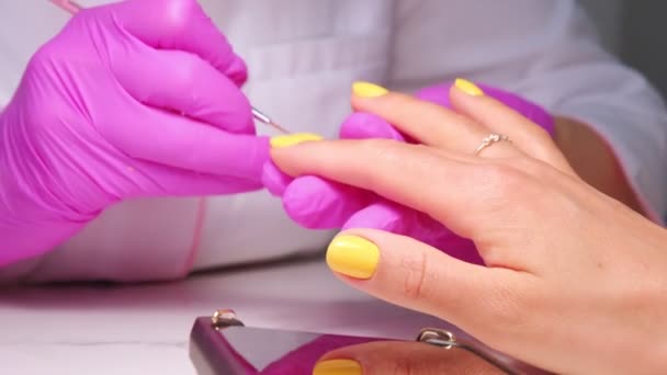 マニキュリストマスターは、クライアントの爪の棚、手を閉じて塗装をカバーしています。美容室でのプロのマニキュア。手の衛生とケア。美容業界のコンセプト. — ストック動画