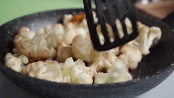 Σωστή διατροφή, χορτοφαγία. Κάτοψη του ψημένου κουνουπιδιού στο τηγάνι. — Αρχείο Βίντεο
