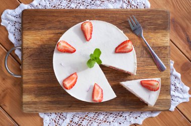 Beyaz arkaplanda bir dilim çilekli cheesecake, seçici odak, kare resim.
