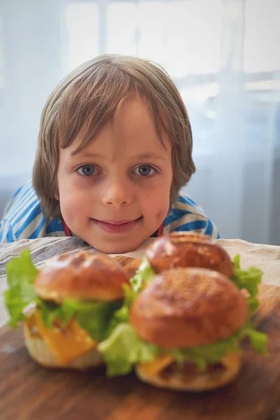 Close up of caucasian boy eating hamburger at barbecue — Stock Photo, Image