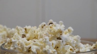 Childs 'ın eli kaseden patlamış mısır alıyor.