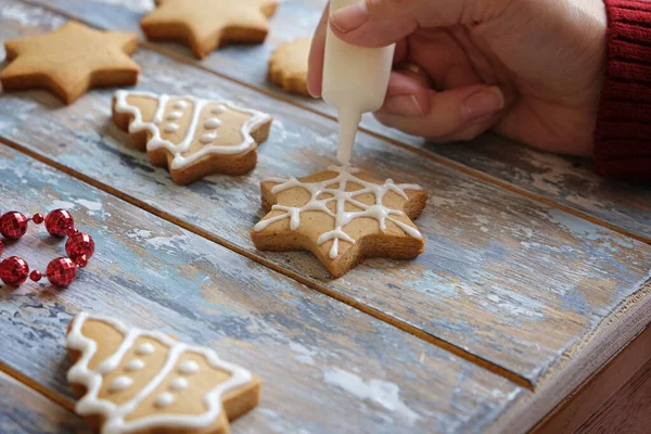 Dokonywanie Christmas ciasteczka imbirowe z białą glazurą dekoracji, zbliżenie — Zdjęcie stockowe