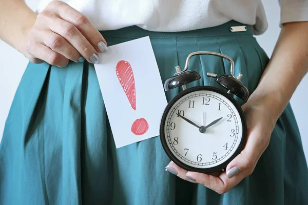 Karnı ağrıyan bir kadın. Gecikmiş dönem, istenmeyen hamilelik, kadınların sağlığı ve adette gecikme..