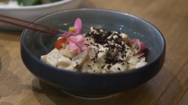 Şef, özel balık tabağını yeşillik ve çiçeklerle süslüyor.