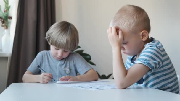 Deux petits garçons assis à la table à la maison et dessinant — Video