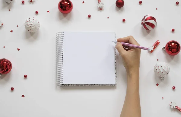 Goal lift for New Year. Holiday decorations and notebook with clean note book on white table, flat lay style. Planning concept.