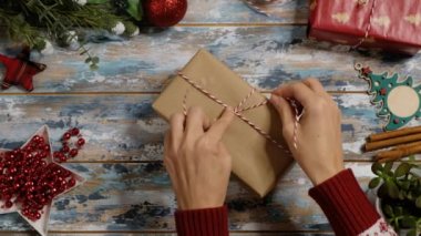 Kadınların elleri Noel hediyelerini paketliyor evde, yukarıdan bakıyor.