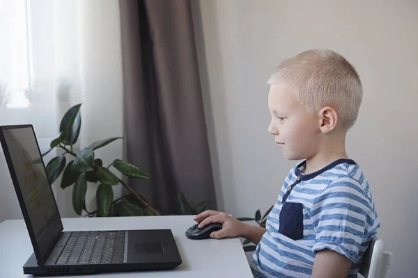 Mladý chlapec pracuje doma na počítači. E-lekce, vzdělávání, programování nebo lekce angličtiny pro děti. — Stock fotografie