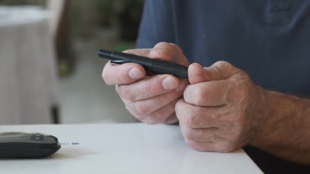 Senior überprüft Blutzuckerspiegel zu Hause mit Glukometer — Stockvideo