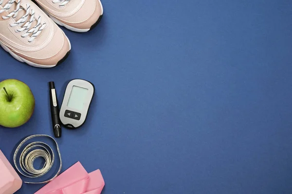 Flat lay with diet diabetes weight loss concept - Sneakers, tape measure, glucometer on a blue background. Place for text