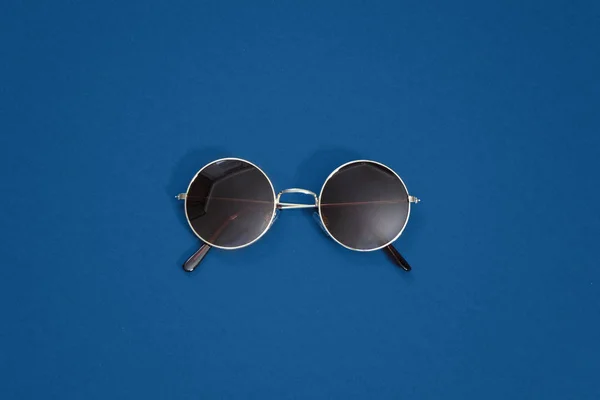 Round retro gold sunglasses on classic blue background - color of the year 2020 — Stock Photo, Image