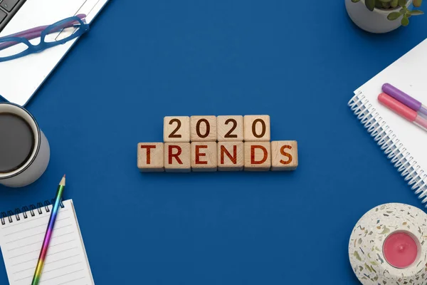 2020 Eğilimleri: ahşap küplerle düz konum ve modaya uygun mavi arka plan ofis malzemeleri