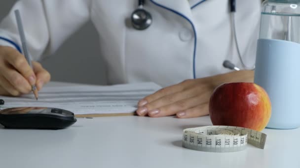 Femmina medico nutrizionista piano di riempimento dieta, primo piano — Video Stock