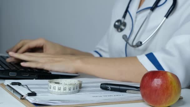 Médica nutricionista trabalhando em um computador, digitando no laptop, close-up — Vídeo de Stock