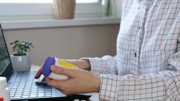 Frau bestellt Medikamente online, tippt auf Laptop und checkt in Drogerie ein. Nahaufnahme — Stockvideo