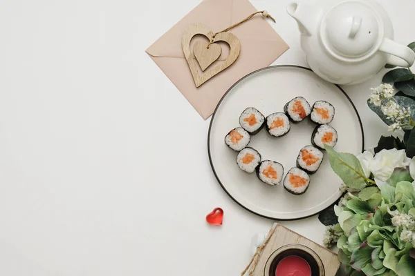 Sushi for Valentines Day - roll in heart shape, on plate on . Flat lay