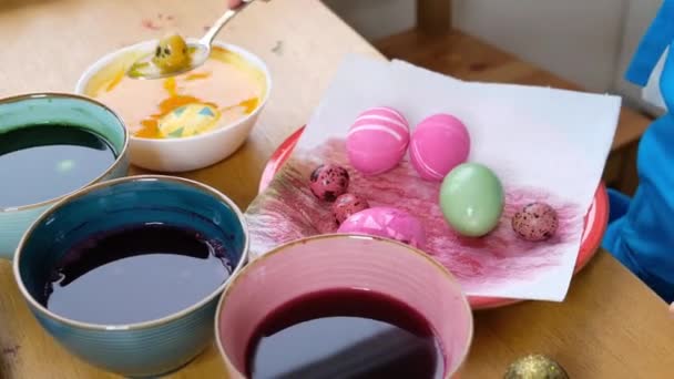 Close-up de mãos de criança colorir ovos de Páscoa com tinta de ovo. Ovos de páscoa coloridos. Preparação da Páscoa — Vídeo de Stock
