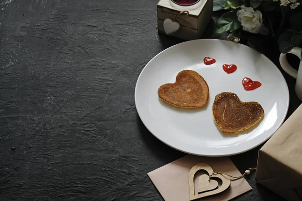 Pancakes heart shaped on white plate, composition for valentines day with food. Space for text — Stock Photo, Image