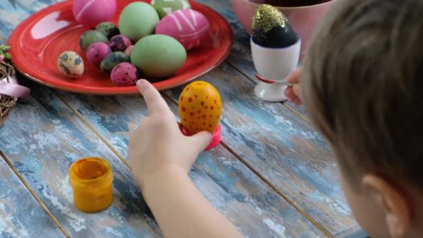 Sluiten van jonge handen kleuren paaseieren met eierkleurstof. Uitzicht van bovenaf — Stockvideo