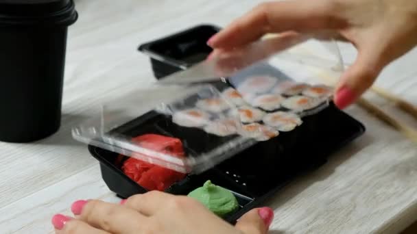 Žena otvírající platikovou krabici se sushi rolkami, zblízka. Koncept dodávky potravin. — Stock video