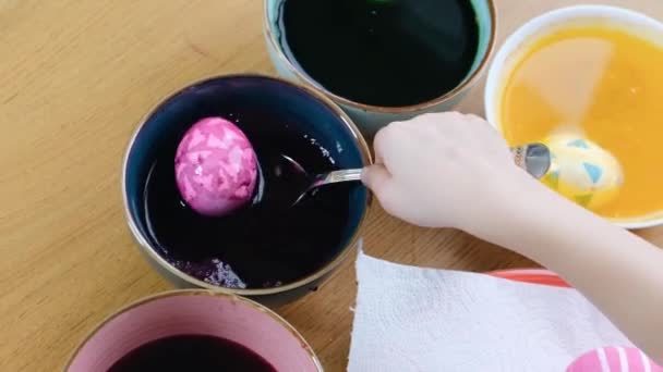 Gros plan de la coloration des mains des enfants oeufs de Pâques avec colorant aux œufs . — Video