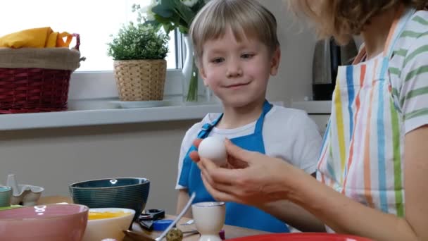 Fem år gammal pojke unge färg påsk ägg med ägg färg. — Stockvideo