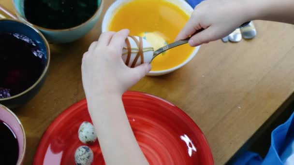 Detail dětských rukou zbarvení velikonoční vejce s vaječným barvivem. — Stock video