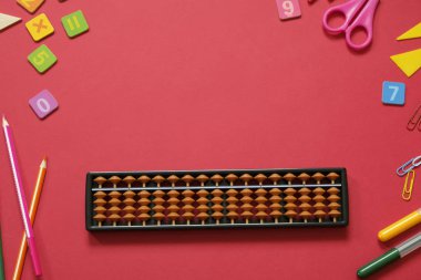 Zihinsel aritmetik ve matematik kavramı: renkli kalemler ve kalemler, sayılar, kırmızı arkaplanda abaküs puanları, kopyalama alanı