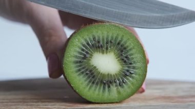 Biri Kivi 'yi bıçakla kesiyor, yakın plan. Makro çekim
