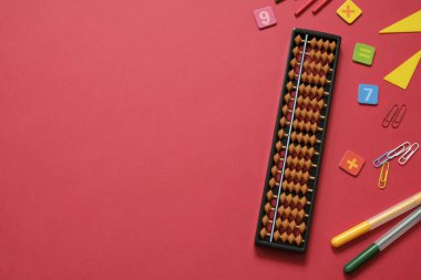 Zihinsel aritmetik ve matematik kavramı: renkli kalemler ve kalemler, sayılar, kırmızı arkaplanda abaküs puanları, kopyalama alanı