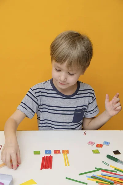 Malý chlapec, příprava na základní škole dělá jednoduché matematické cvičení — Stock fotografie