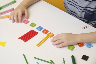 Küçük çocuk basit matematik egzersizleri yaparak ilkokula hazırlanıyor. Kapat.