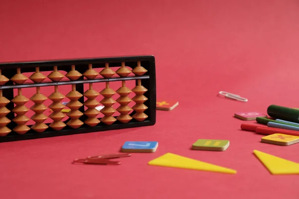 Mental arithmetic and math concept: colorful pens and pencils, numbers, abacus scores on red background, copy space — 스톡 사진