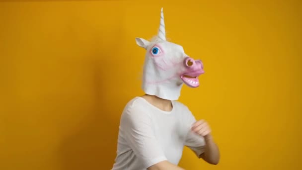 Bizarre drôle de vidéo femme avec la tête de licorne dansant sur fond jaune — Video