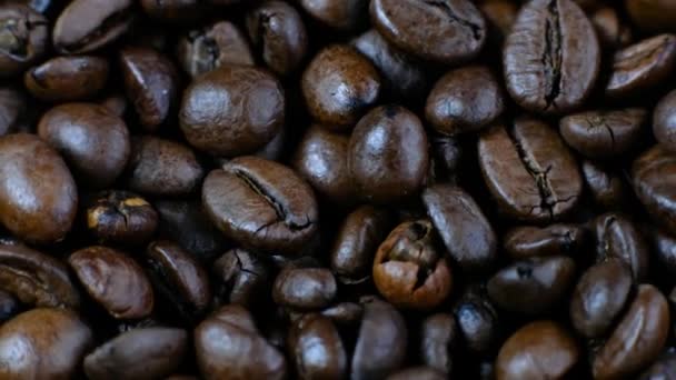 Mörka kaffekorn. Kaffebönor roterar. Närbild av kaffefrön. — Stockvideo