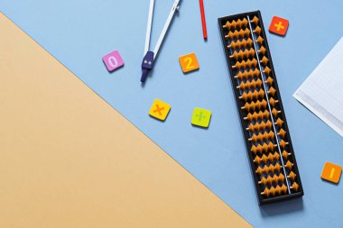Okul malzemeleri, pusula, bej arka planda numaralar olan yaşlı abaküs. Zihinsel matematik, matematik konsepti.