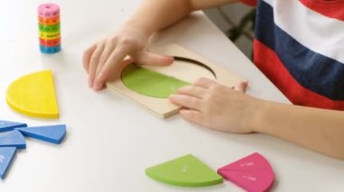 Beyaz masa üzerinde kesirlerle basit matematik alıştırmaları yapan çocuk el, kapat. Kesirler bölünüyor
