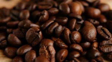 Koyu kahve taneleri. Kahve çekirdekleri dönüyor. Kahve tohumlarını yakın..