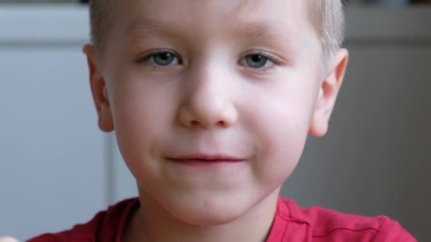 Gracioso sorprendido niño rubio sorprendido, niño pequeño con grandes ojos. De cerca. — Vídeo de stock