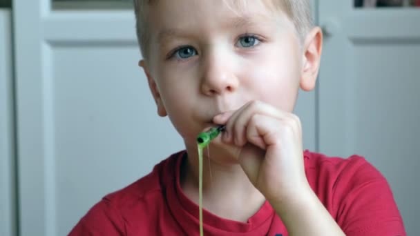 Μικρό παιδάκι που παίζει με ανοιχτόχρωμη πράσινη γλίτσα. Κλείσε. — Αρχείο Βίντεο