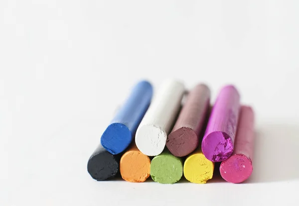 Colorful pastel crayons on white background with copy space. Art, drawing concept. Macro shot — Stok fotoğraf