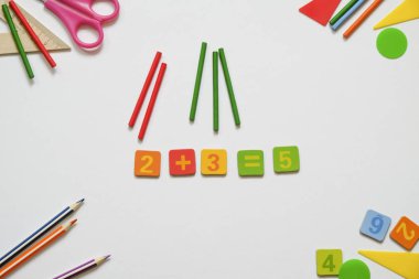 Math concept: colorful pens and pencils, number, calculating sticks in white background. Mathematics